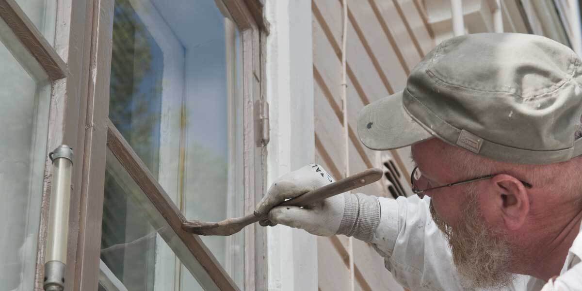 man painting window frames