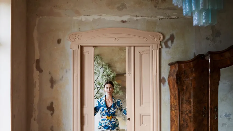 Henkilö seisoo Tikkurilan maaleilla maalatun huoneen ovella.